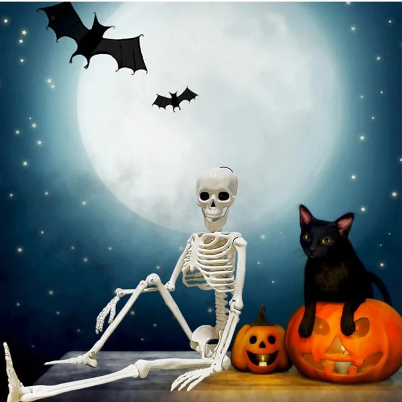 Poseable Halloween skeleton sitting beside pumpkins and a black cat